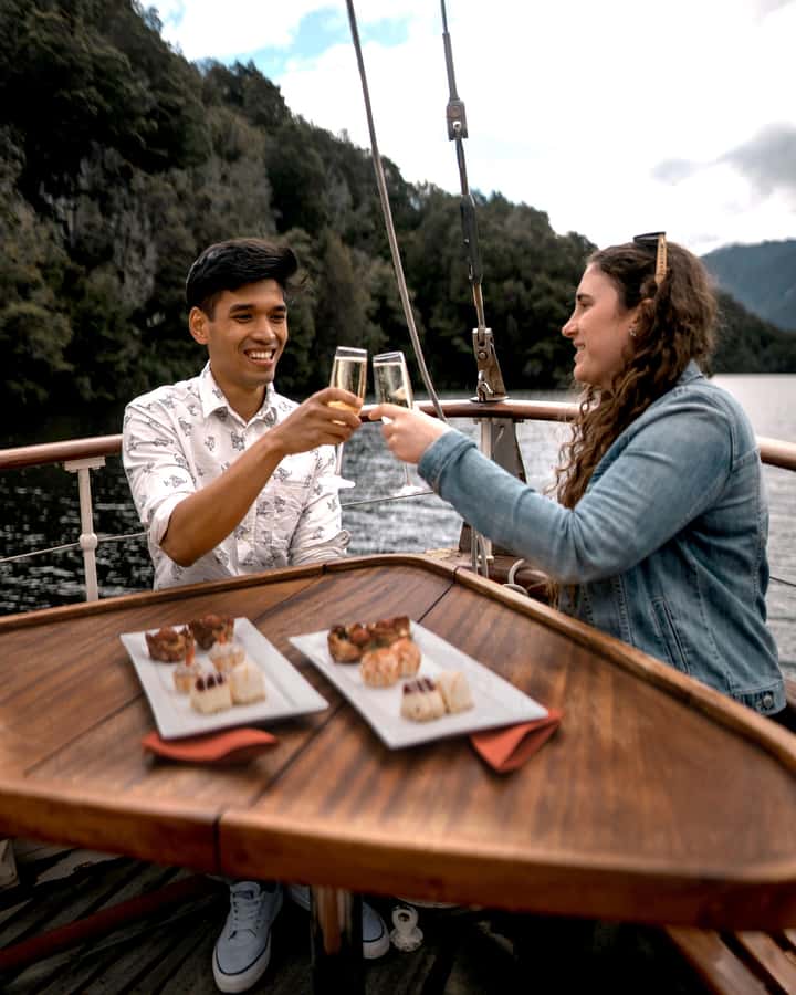 Evening Champagne Cruise on Historic 1935 Motor Yacht. - Cruising Lake Te Anau with a glass in hand